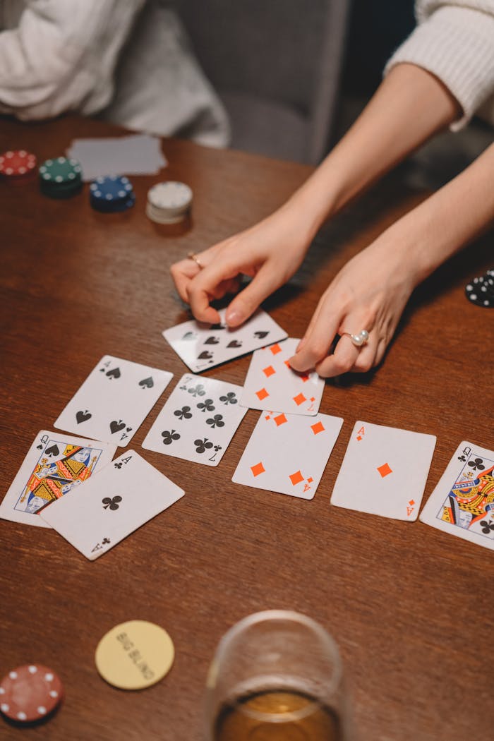 A close-up shot depicting a poker game in progress on a wooden table.